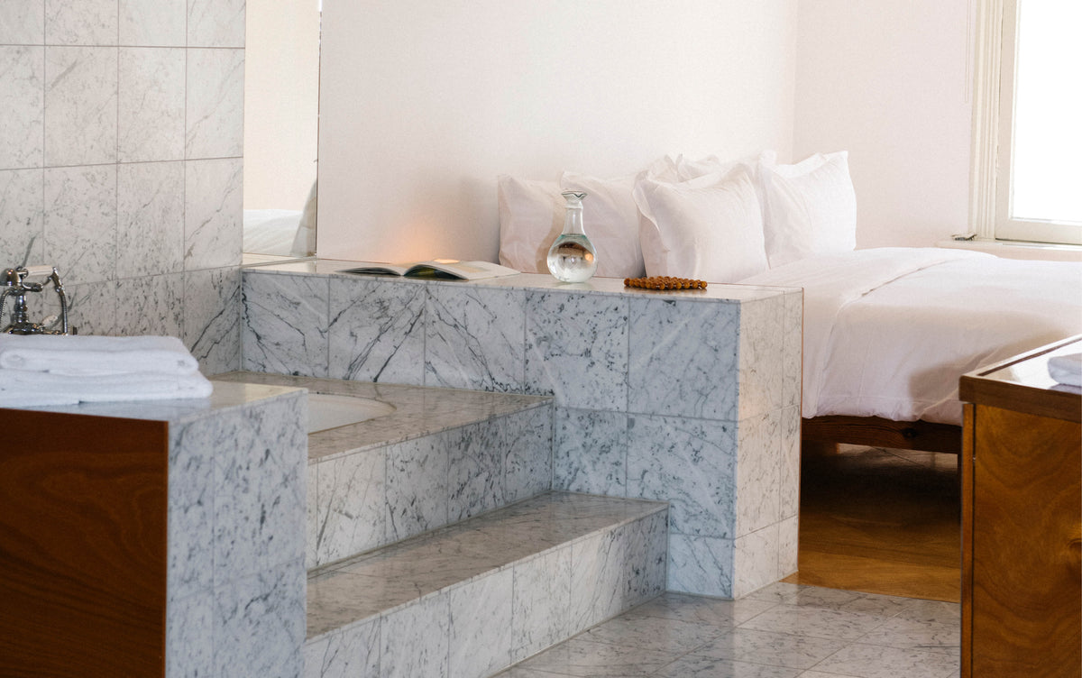 Guest suite with a marble bath and a double bed at the CARMEN guesthouse in Amsterdam